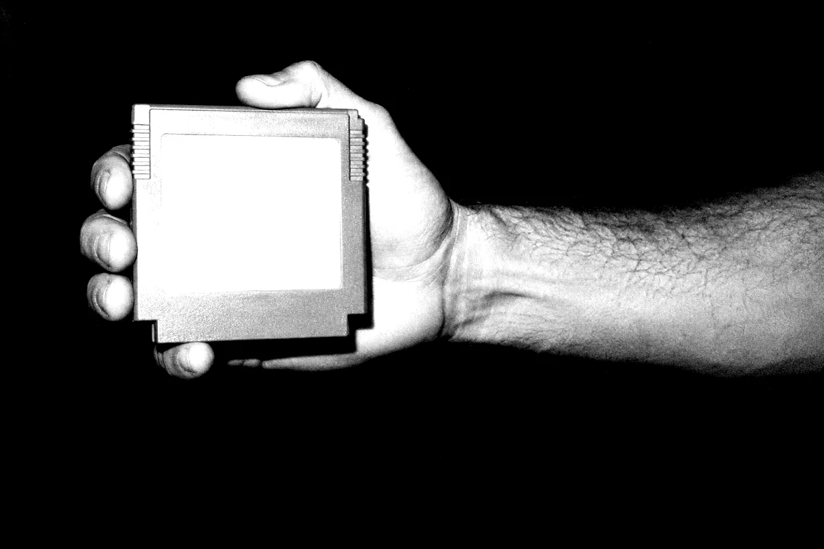 A hand holding a blank cartridge