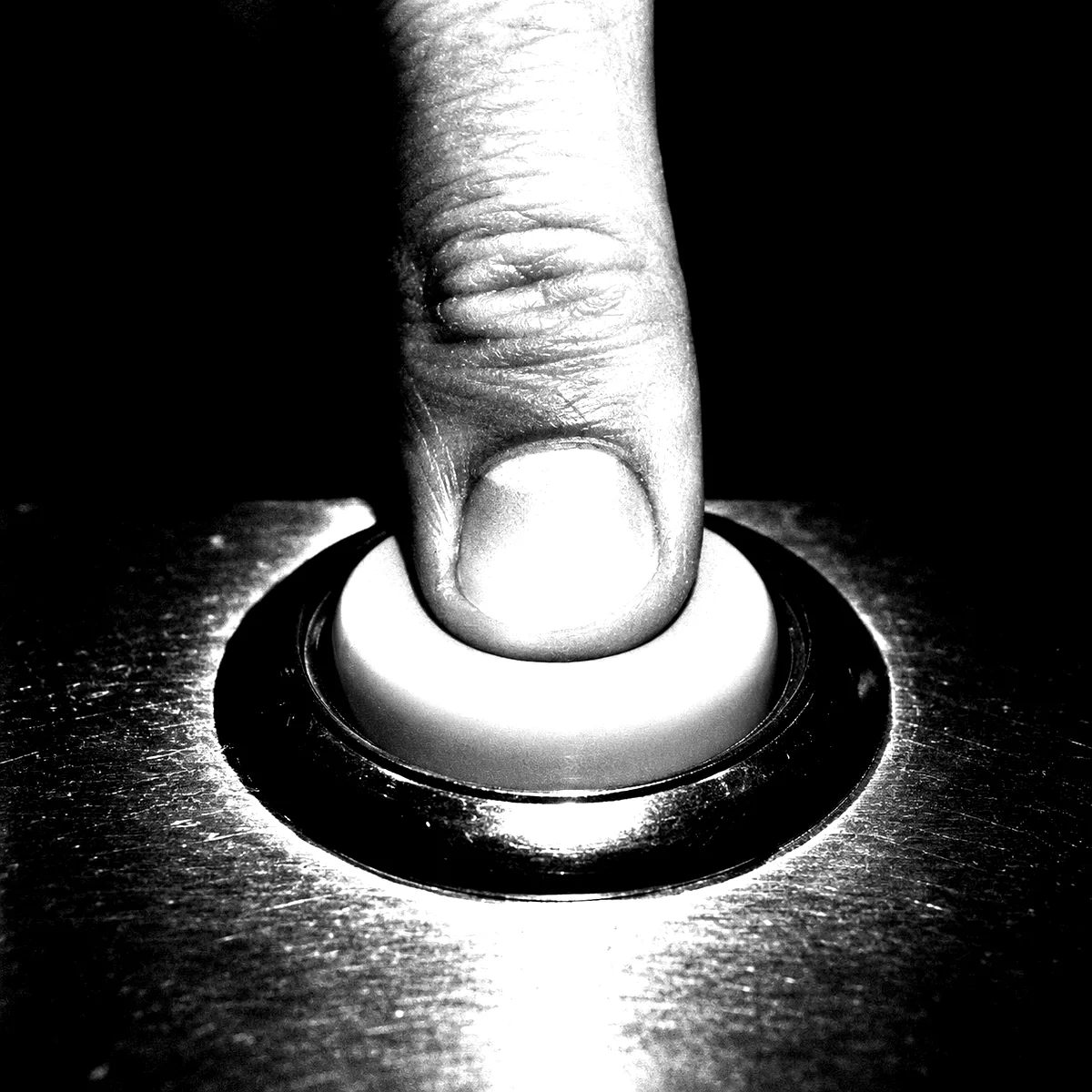 A finger pressing a large unmarked button